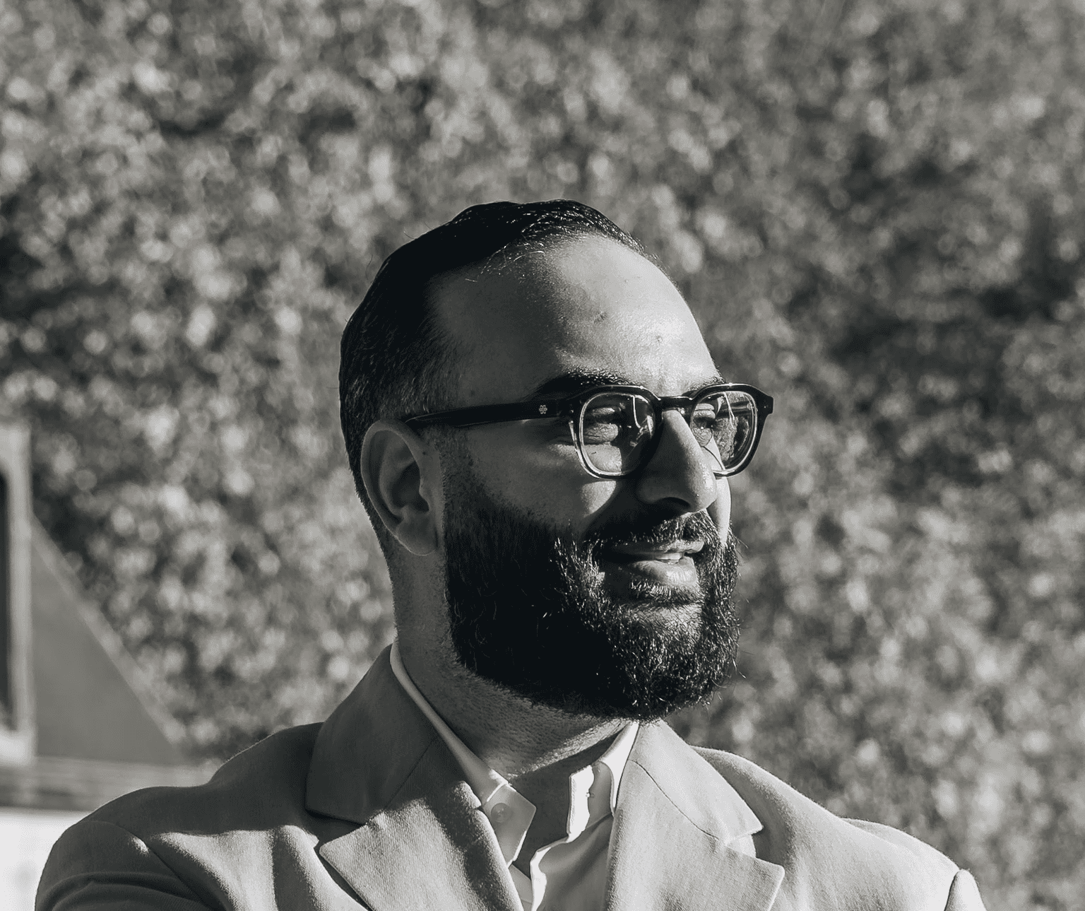 Portrait of a person in a pink sweater against a light background