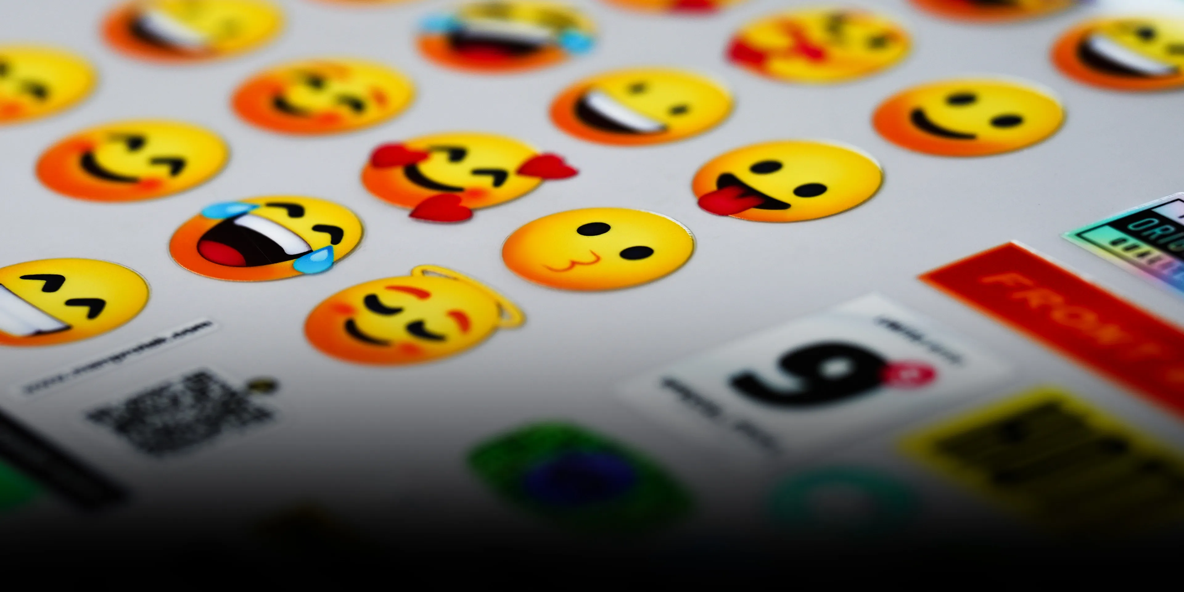 Close-up photo of vibrant emoji UV DTF stickers, demonstrating Printera Studio's near 100% original-quality output capable of flawlessly reproducing very thin lines, complex shapes, and diverse colors