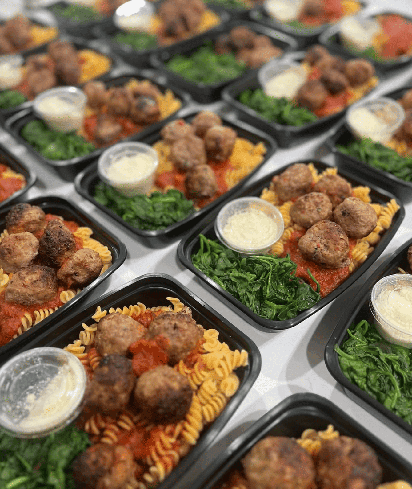 Albóndigas de pavo sobre pasta integral con salsa de tomate y espinacas salteadas.
