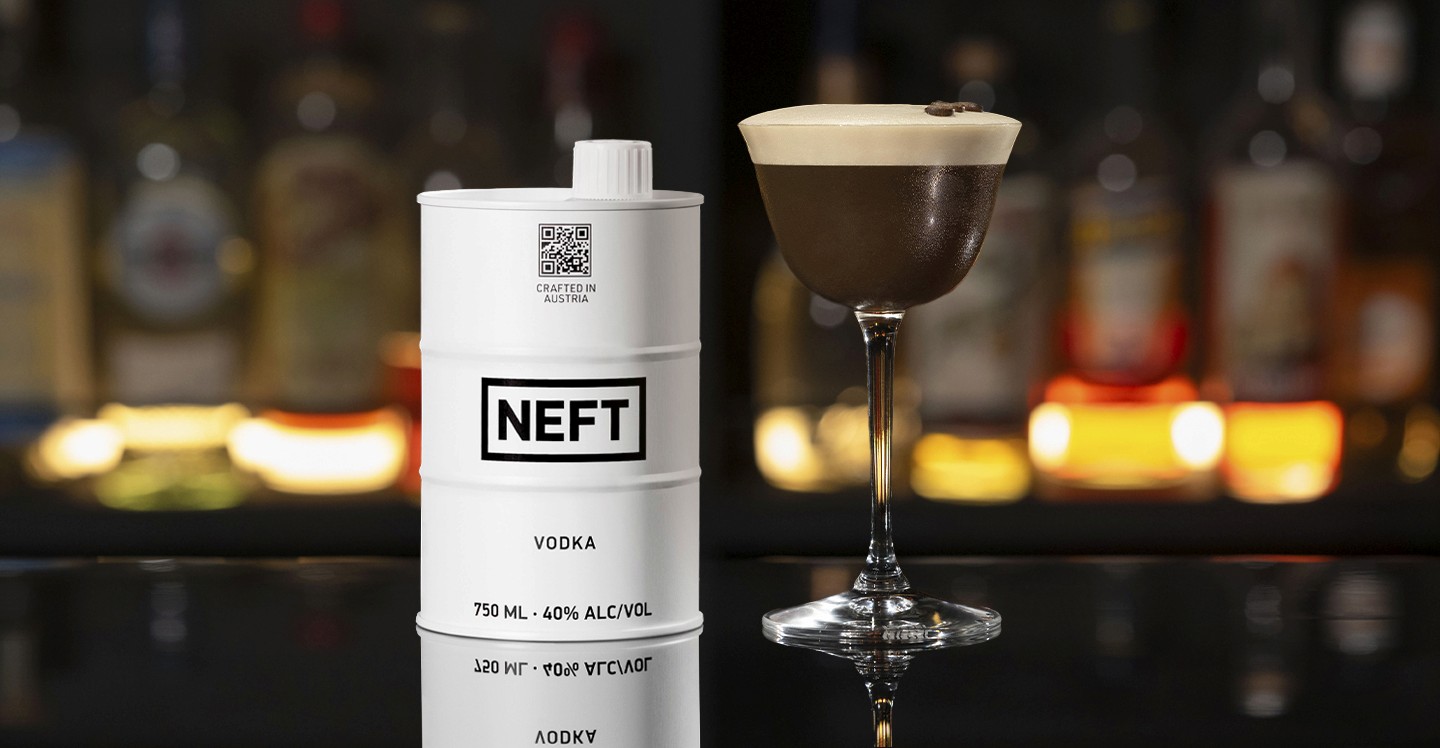 A NEFT Barrel and a glass of Egg White Espresso Martini on a bar counter.