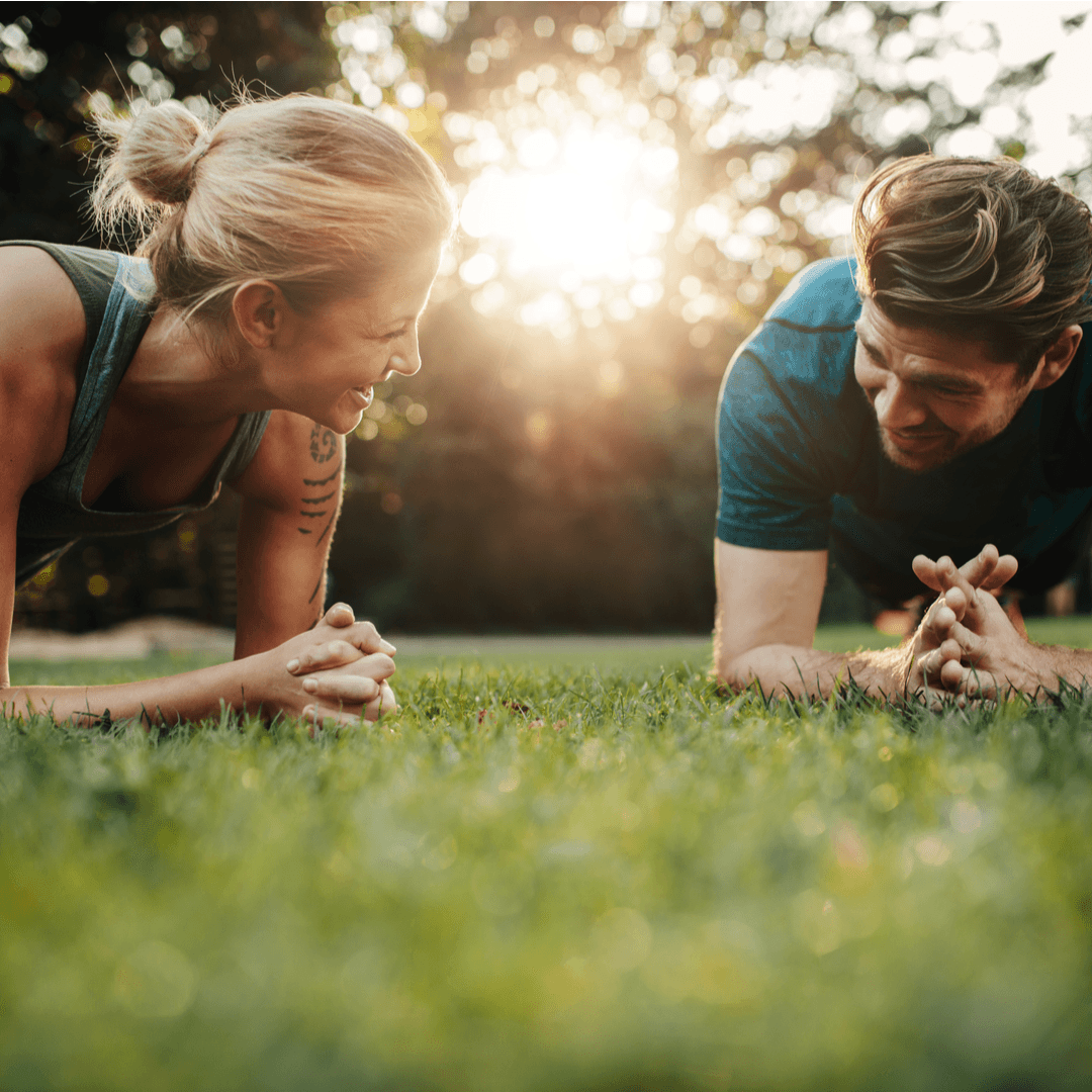 Man and woman working out in park