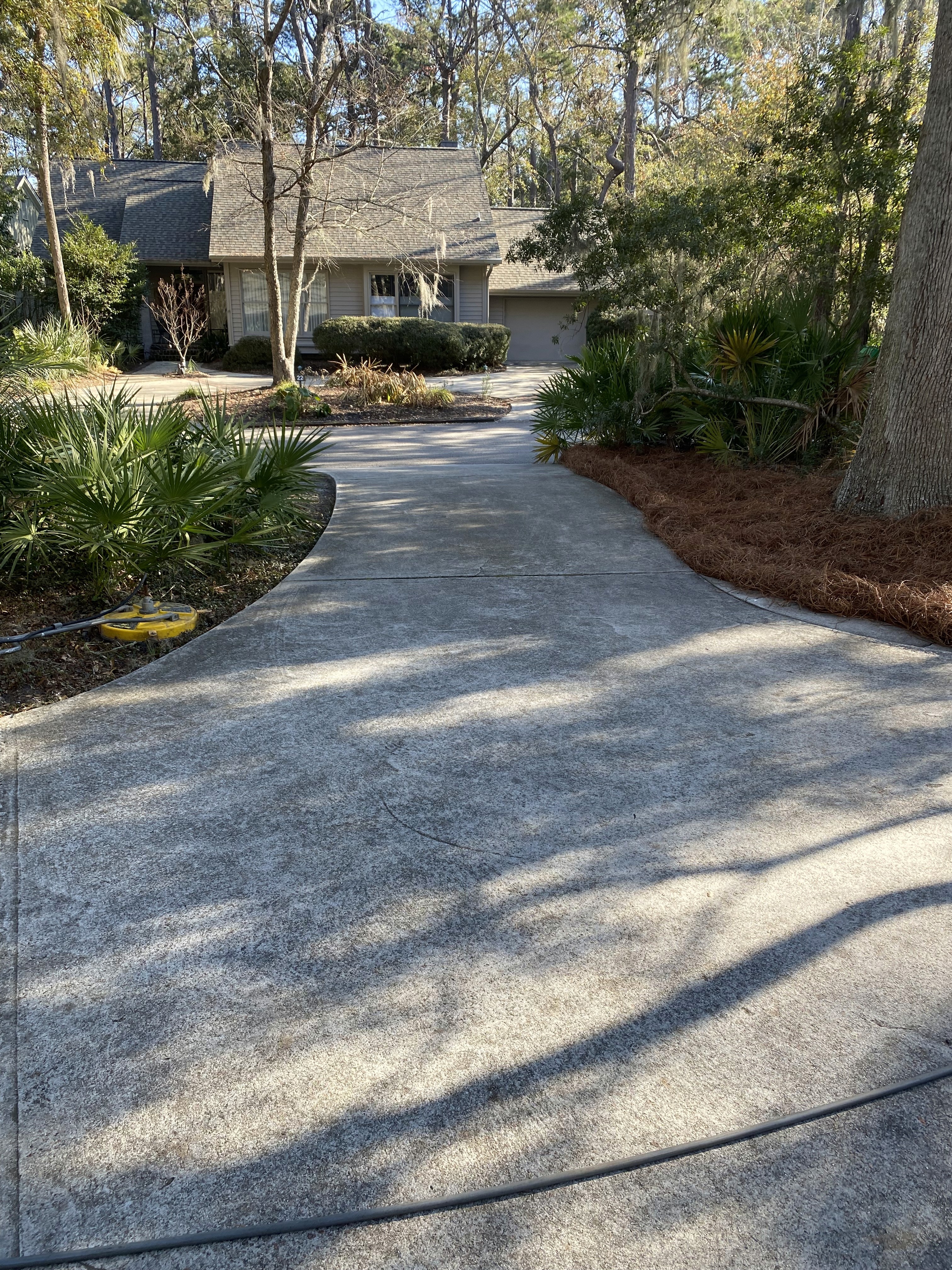 Before and after—driveway power washed in Hilton Head SC, showing restored clean concrete