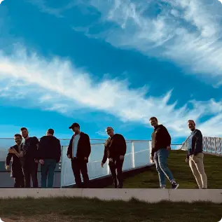 people pictured from below underneath a blue sky