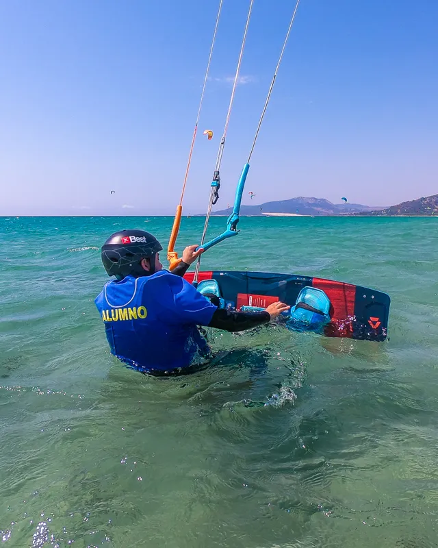 Anfänger-Kitesurfer bereitet sich bei Explora Watersports Tarifa mit dem Board auf den Wasserstart vor