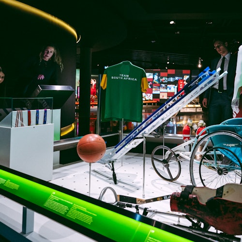 ਸੰਗ੍ਰਹਾਲੇ ਦੇ ਸੰਦਰਭ ਵਿੱਚ ਖਿਡਾਰੀ ਉਪਕਰਣ ਦਿਖਾਉਂਦੇ ਹੋਏ, "ਟੀਮ ਦੱਖਣੀ ਆਫ਼ਰਿਕਾ" ਦਾ ਜਰਸੀ, ਬਾਸਕਿਟਬਾਲ ਅਤੇ ਇੱਕ ਵੀਂਚੇਅਰ।