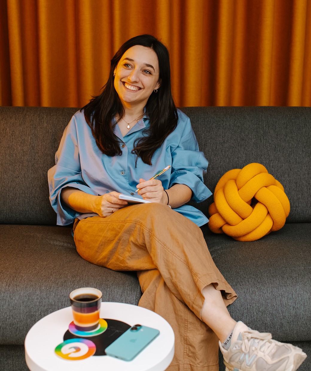 Smiling woman sitting on the couch, taking notes