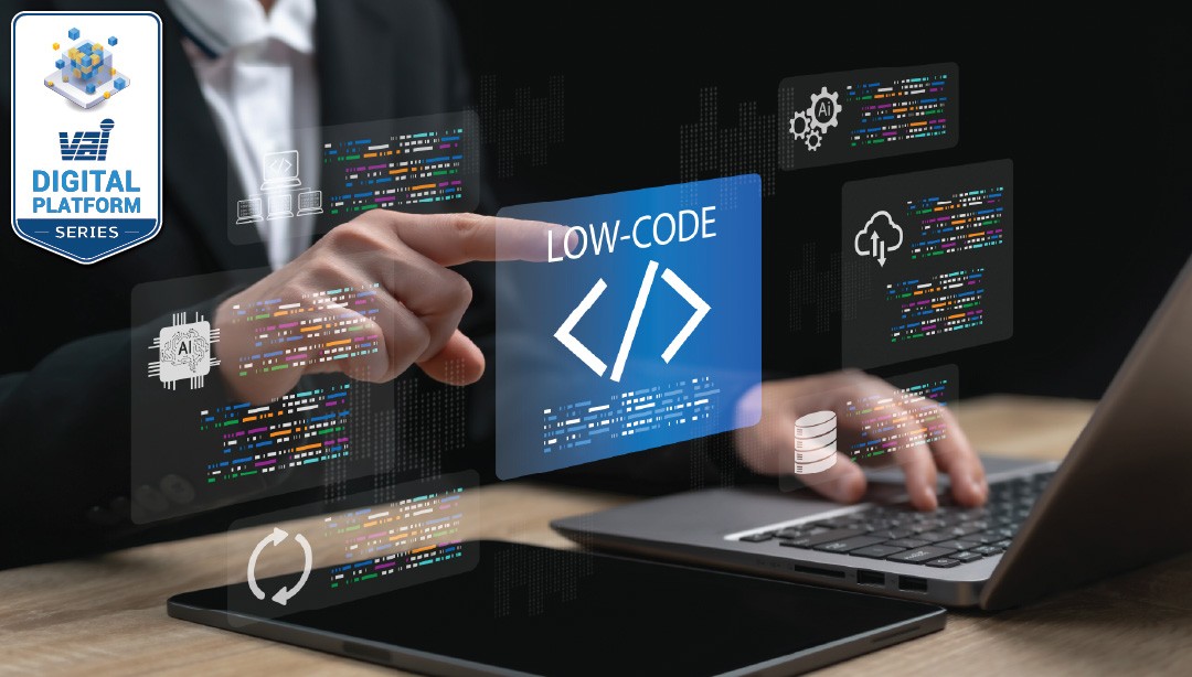 A person in a suit points at a floating coding symbol above a laptop on a dark desk background.