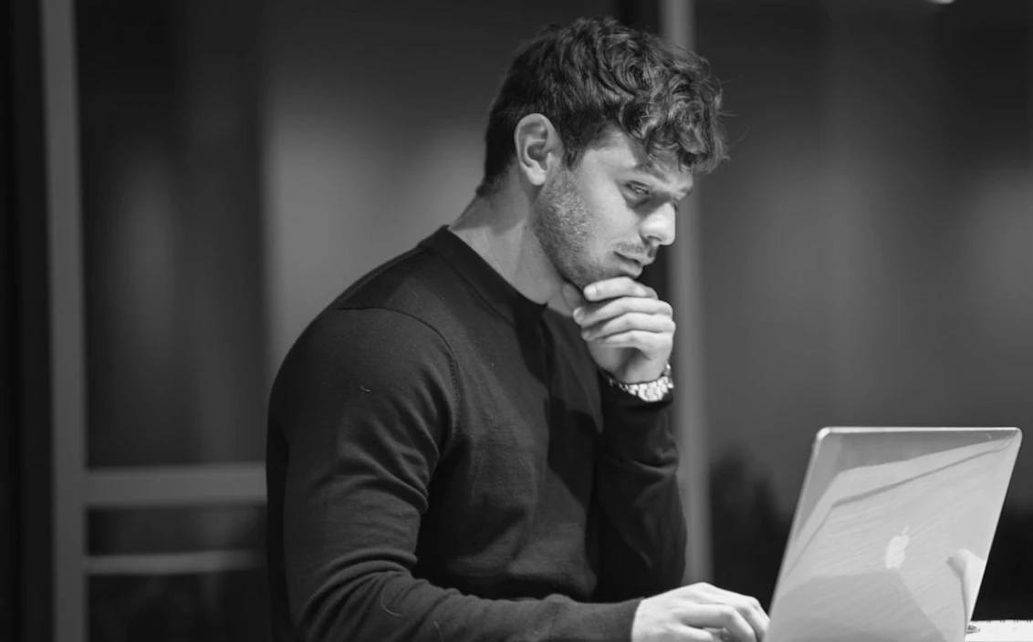 A man thinking at a computer screen