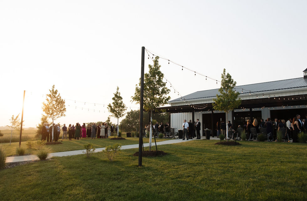 Guests gathering beside the covered patio at sunset