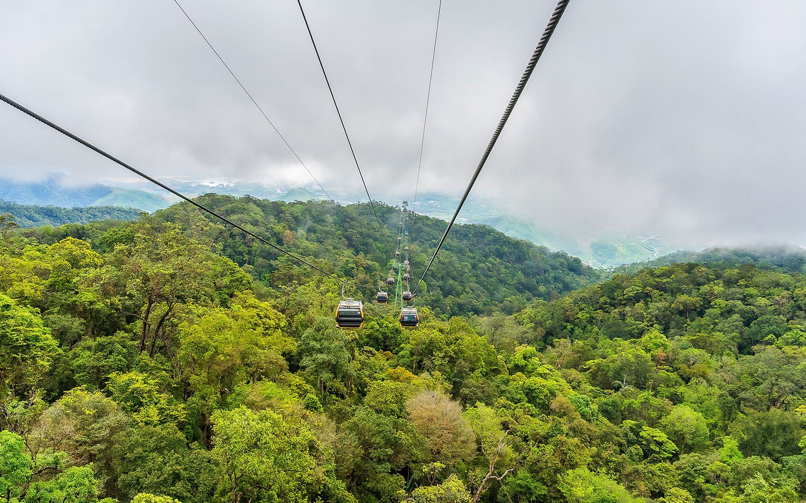 Cable car over lush forest at Sun World Ba Na Hills, Vietnam.