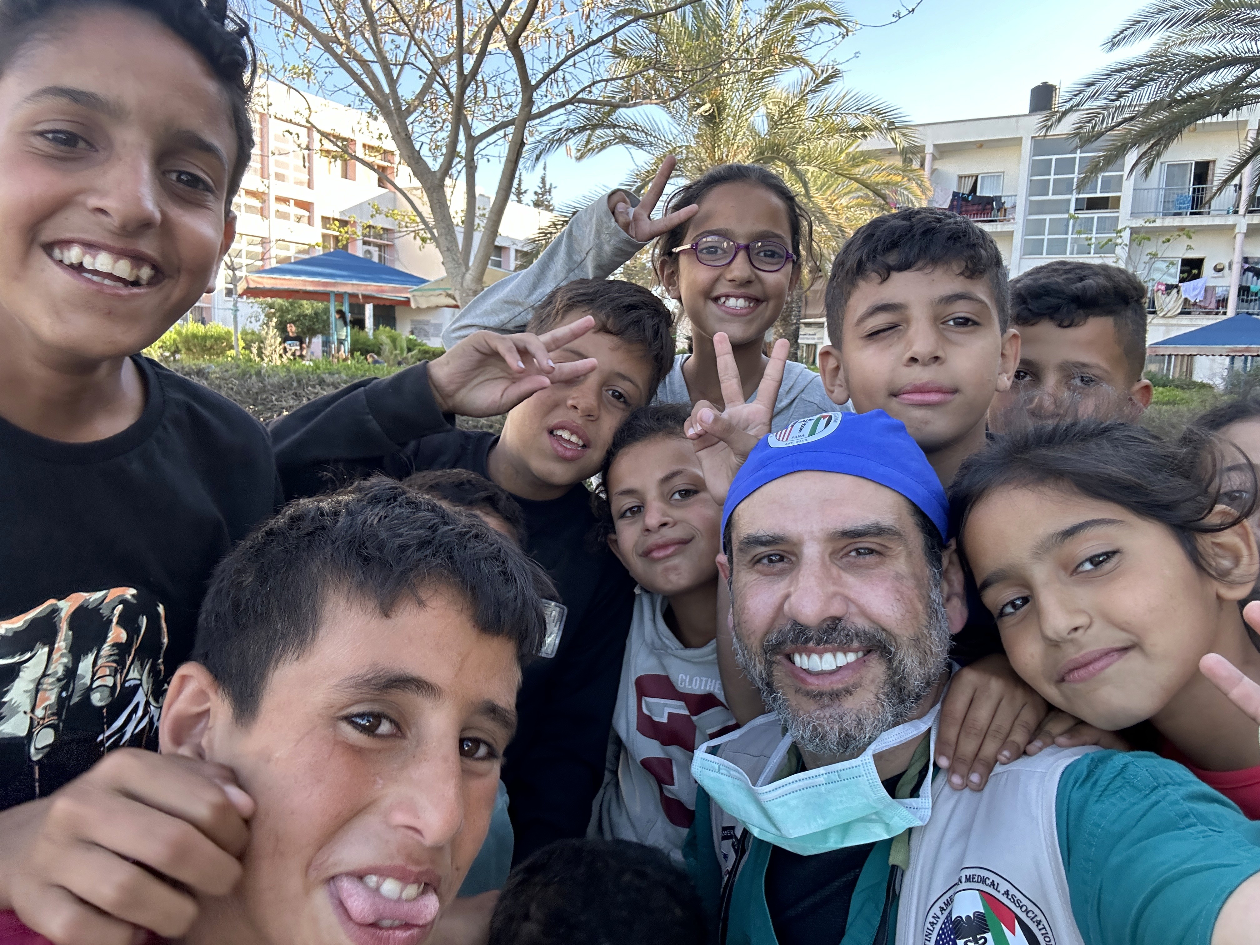 A group of children and an adult smile for a selfie outdoors, displaying joy and camaraderie.