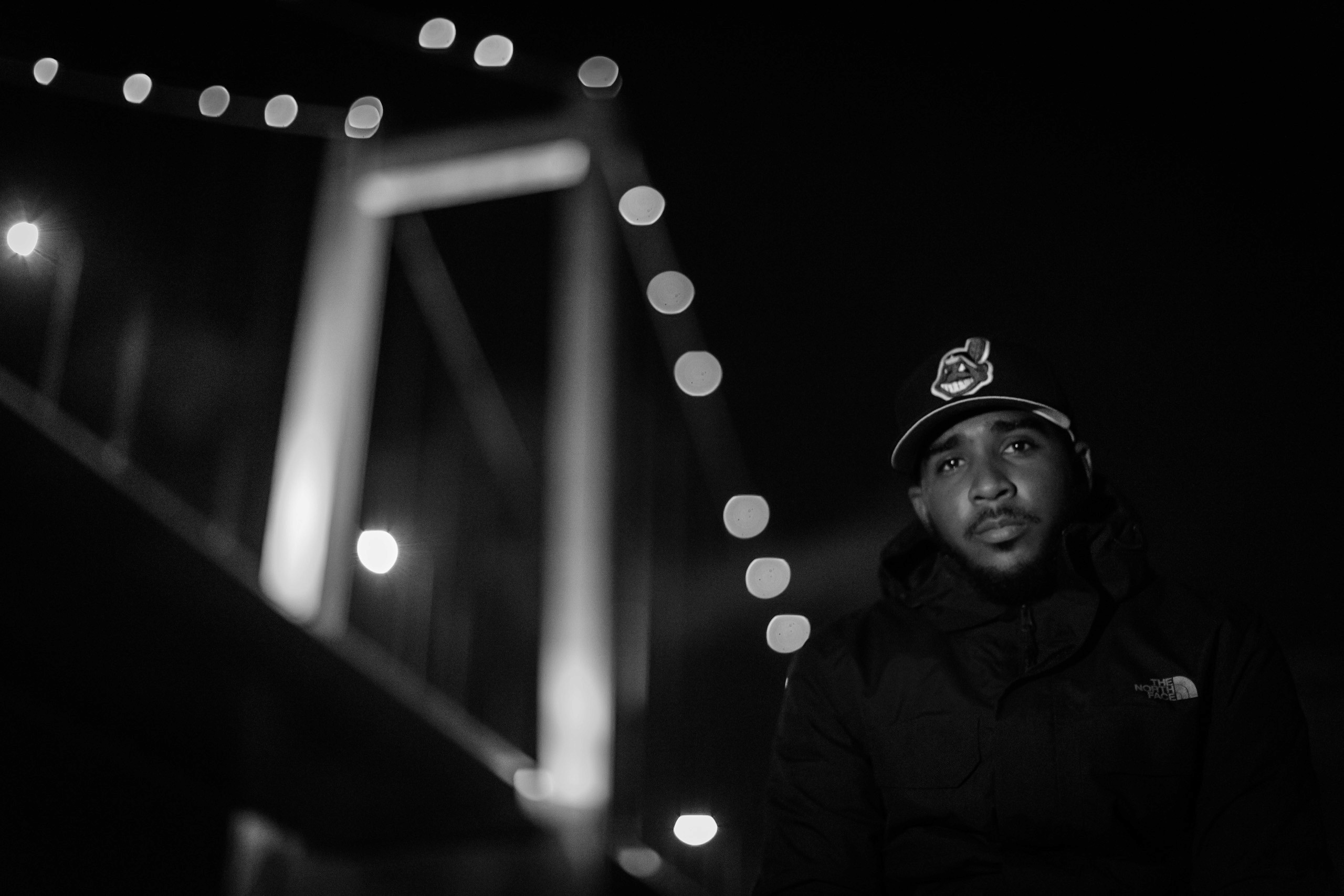 Black and white photo of a man with bridge in the background