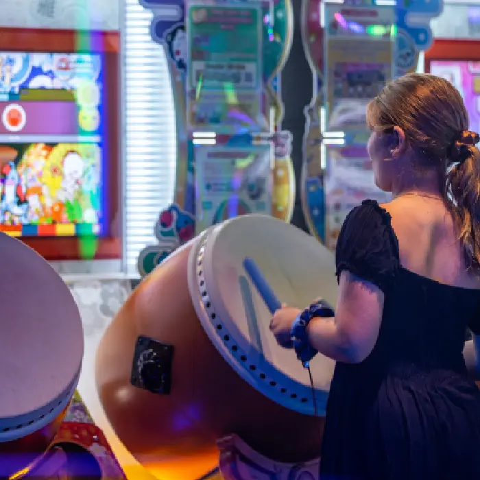 A person playing a drum arcade game at Fortress