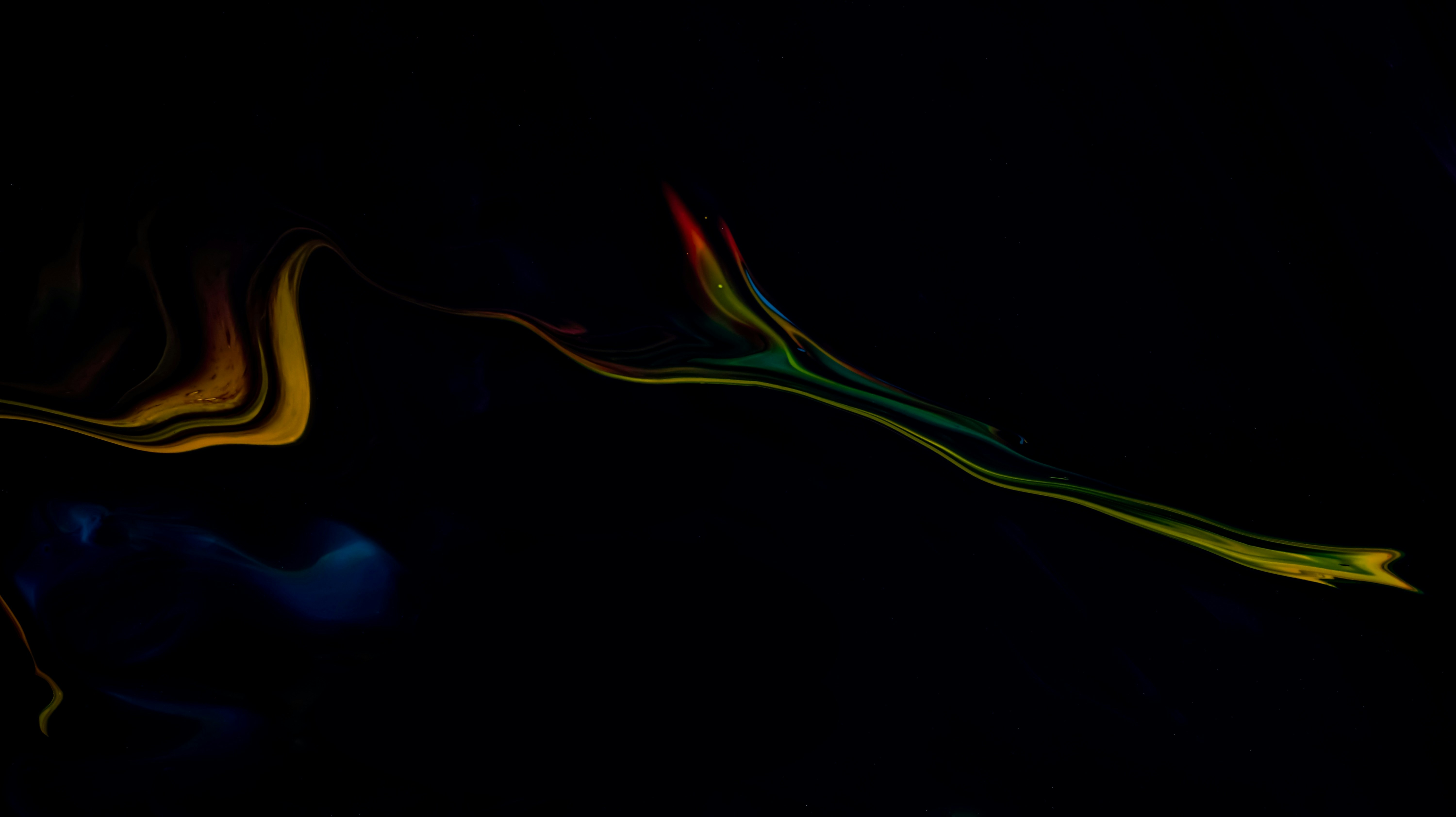 Close-up portrait of a person wearing a gray insulated hooded jacket with the hood up, showing their face framed by the hood against a light background.