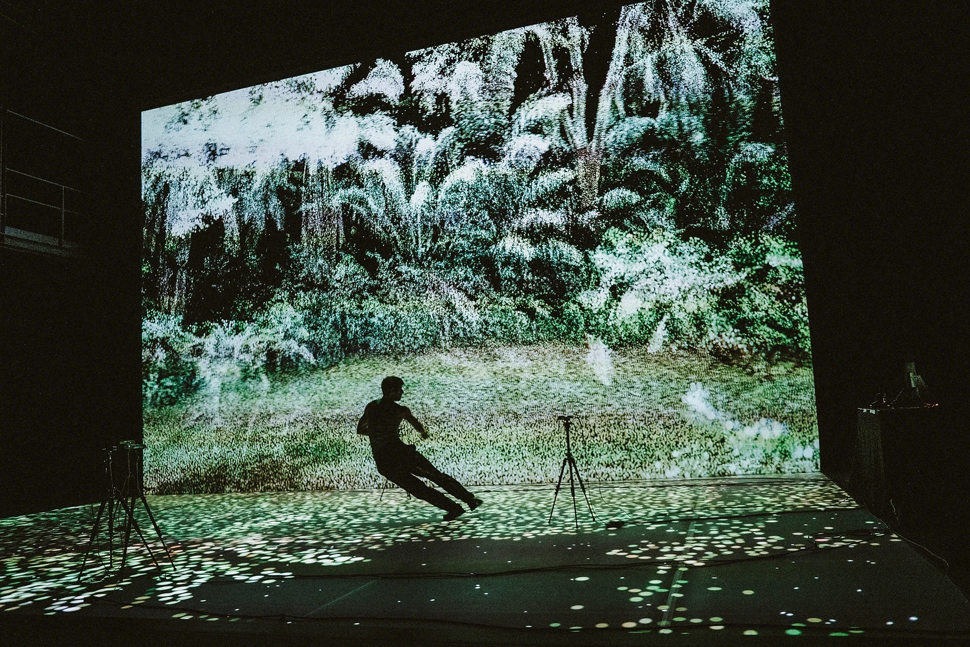 Silhouette dancer on stage with forest projection