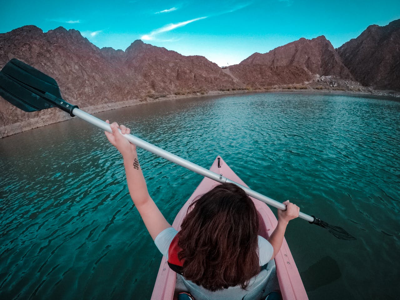 A woman paddles her kayak in the waters of Hatta, Dubai.