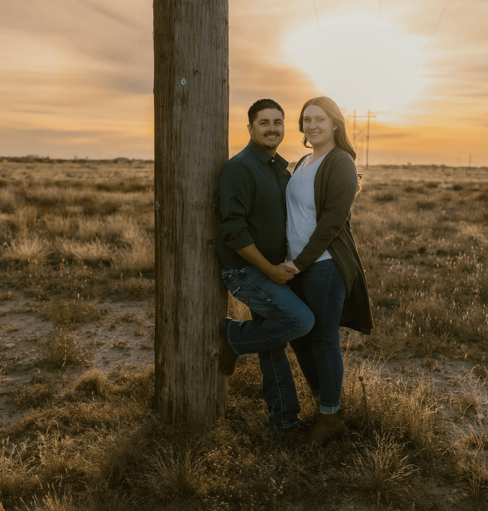 A bride and groom share a kiss surrounded by a joyful bridal party.