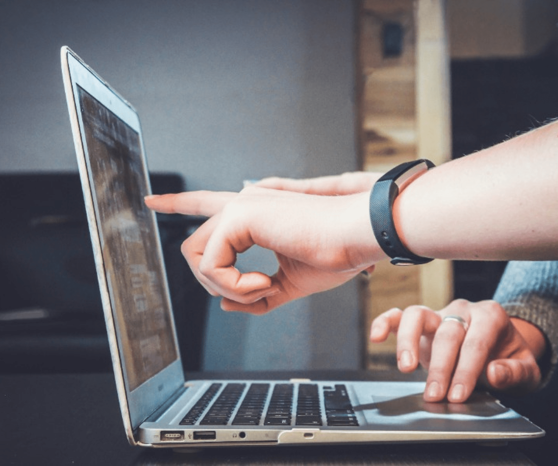 Person pointing at their website on a laptop