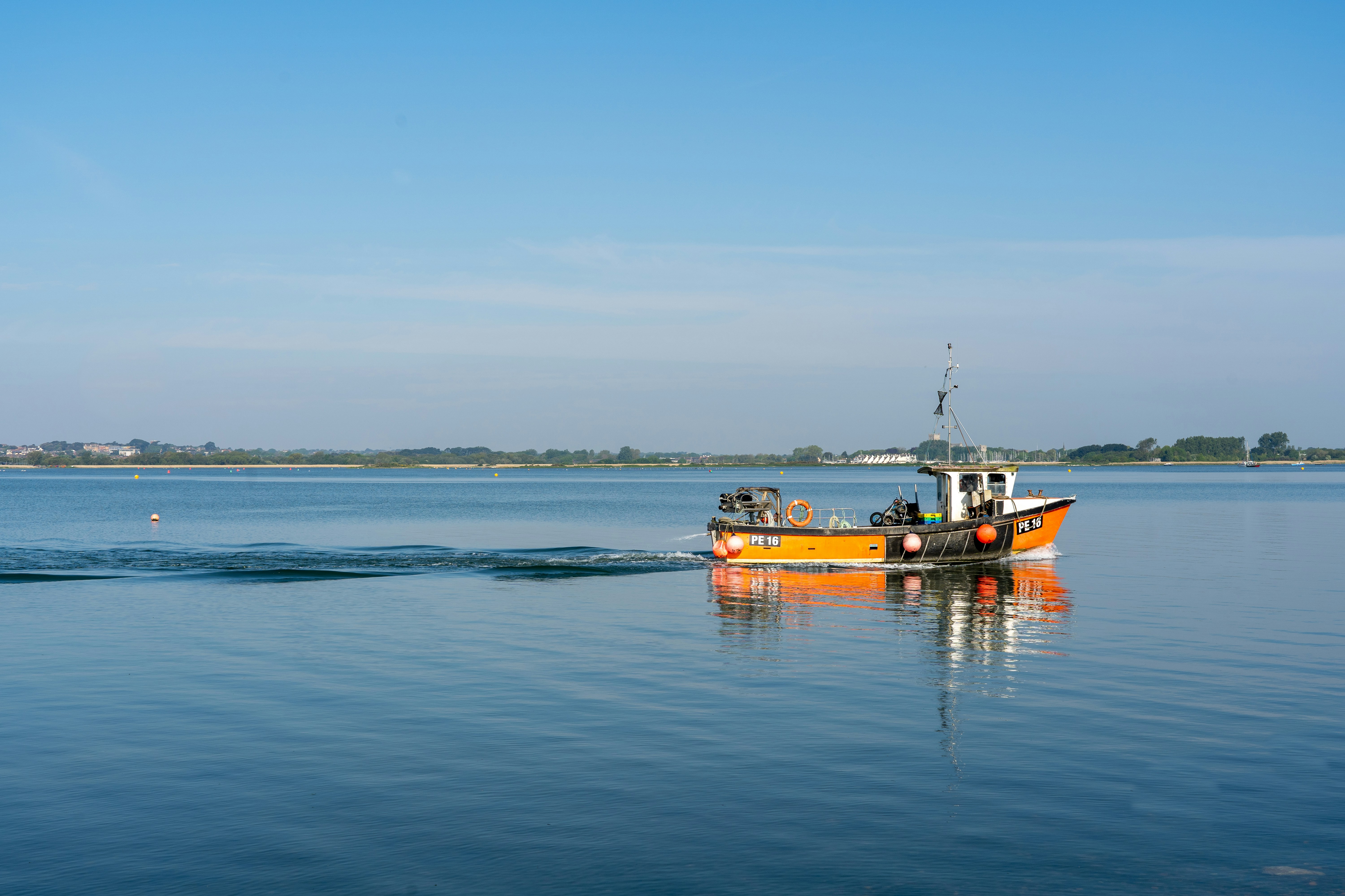 A small fishing boat crossing calm blue water