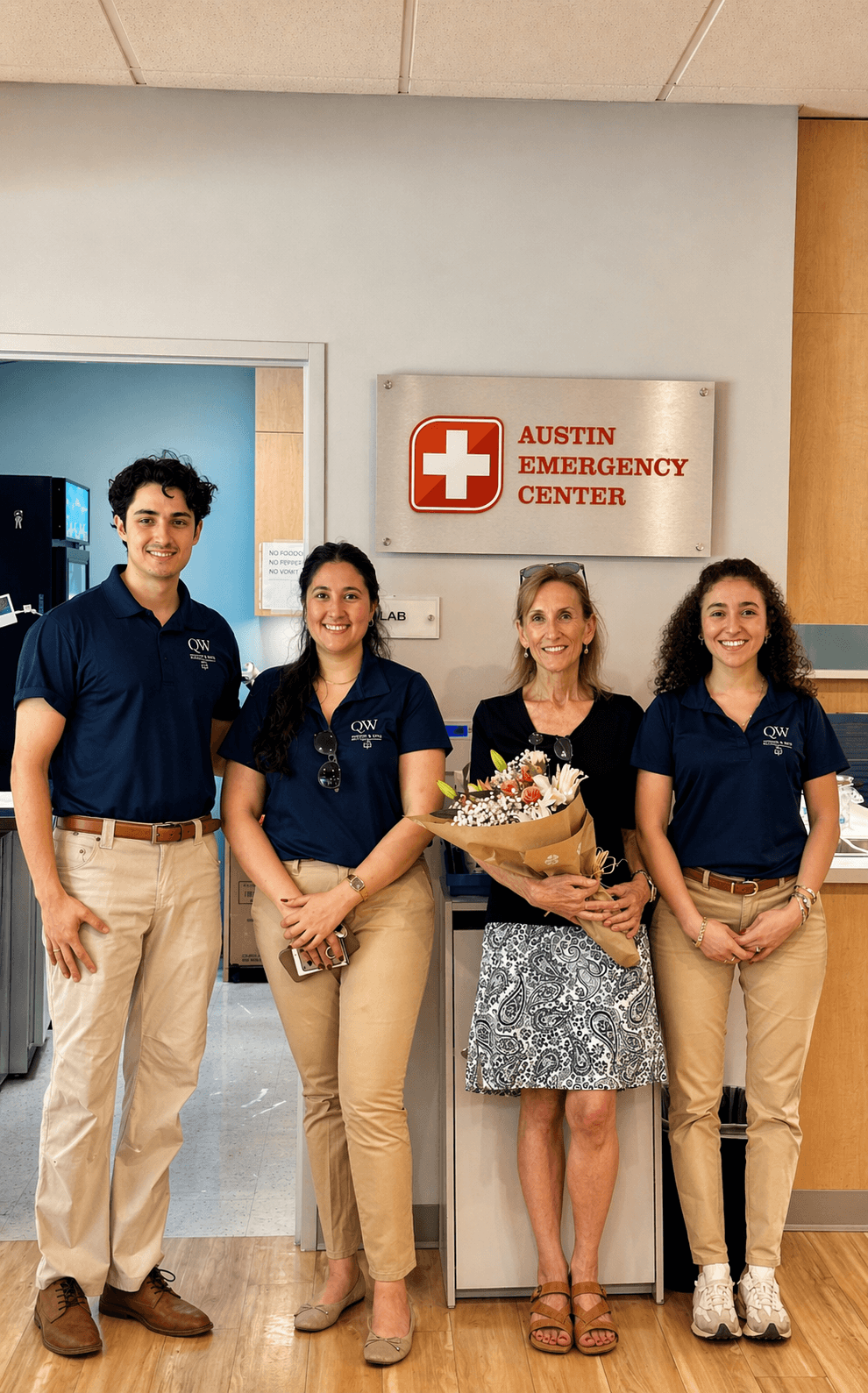 QW Kitchen & Bath installation team with satisfied client at Austin Emergency Center project completion