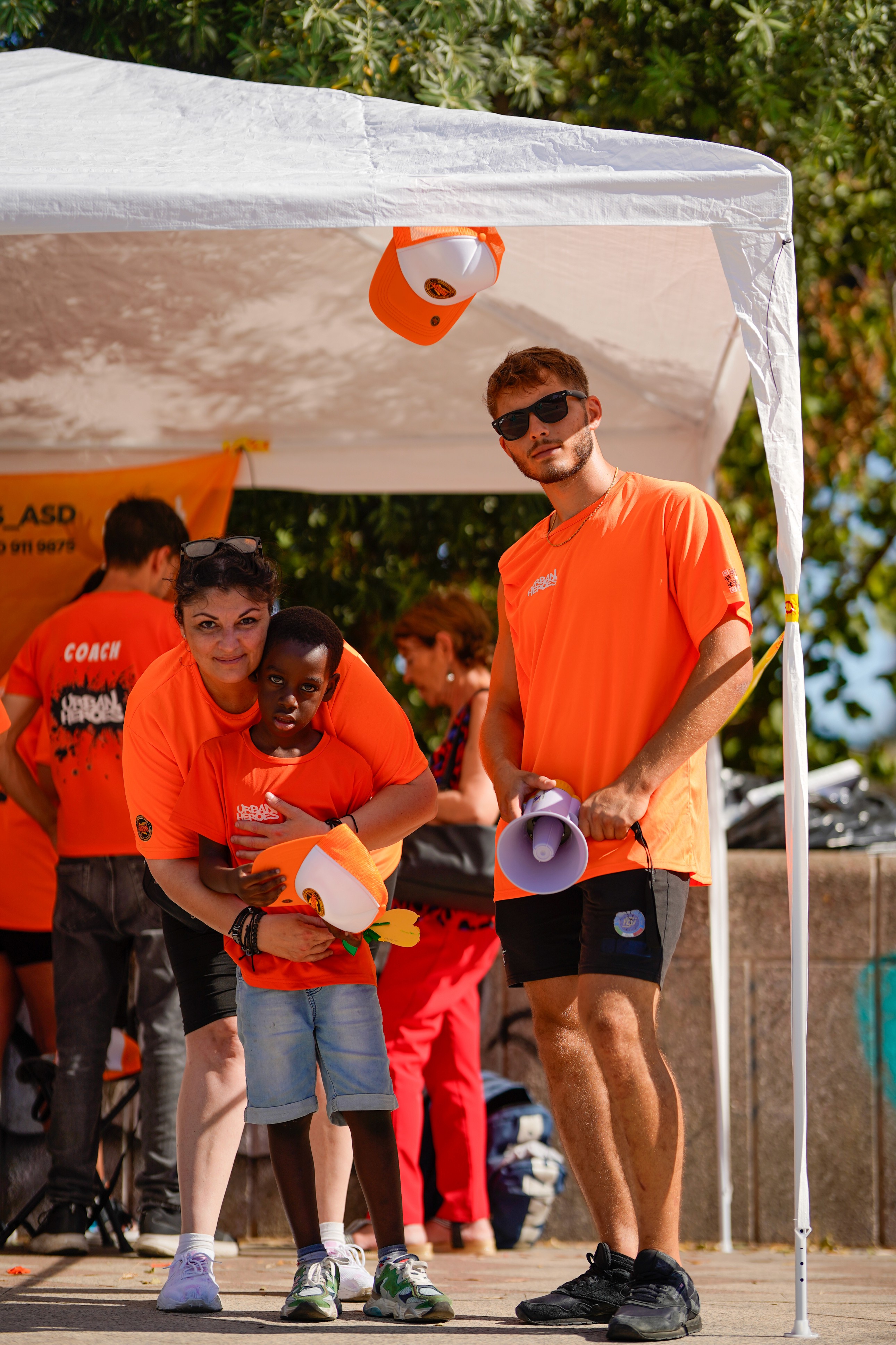 istruttor ifanno una foto con un atleta bambino tutti con maglie urban heroes