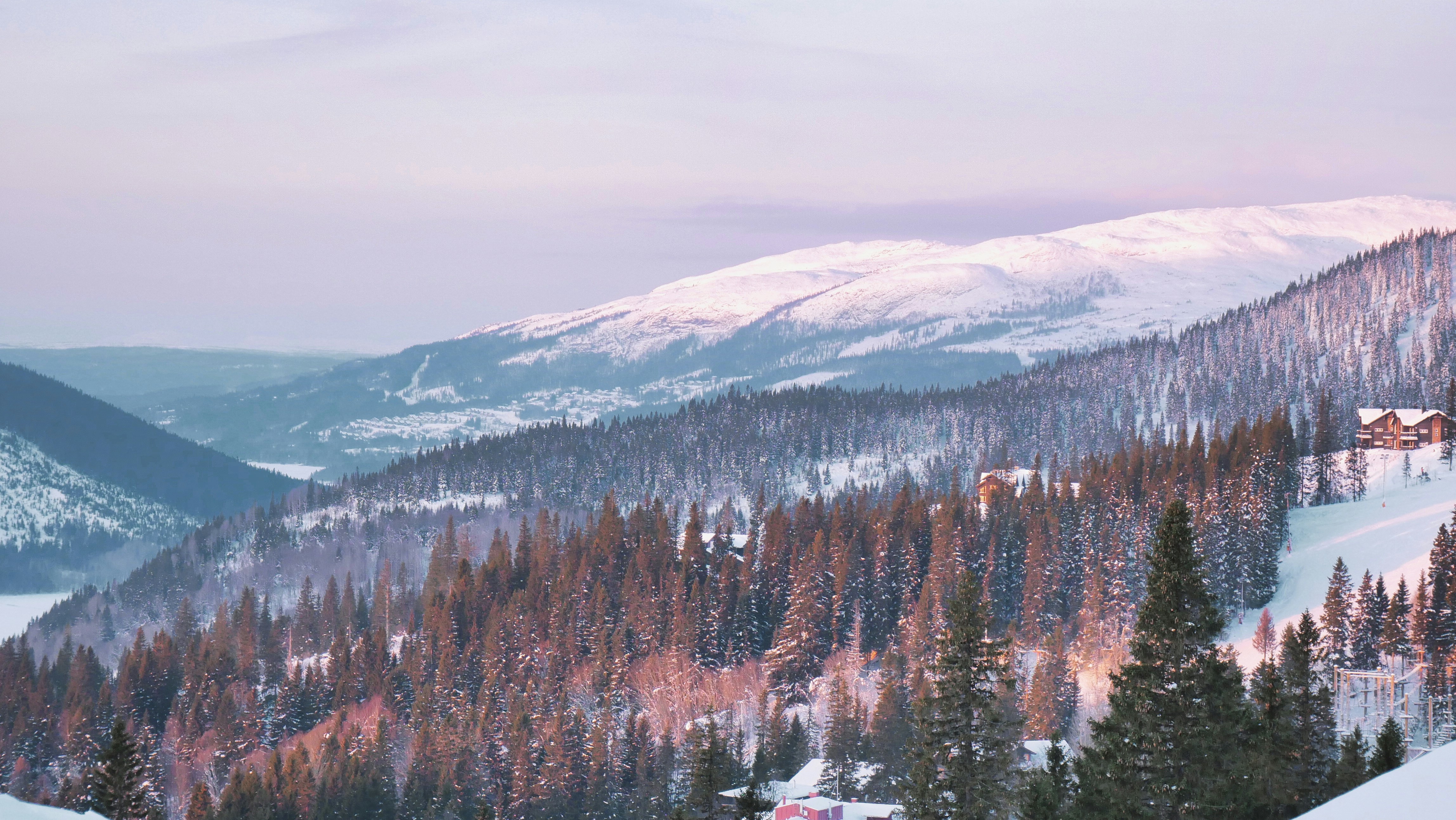 a snow covered mountain with a house in the distance