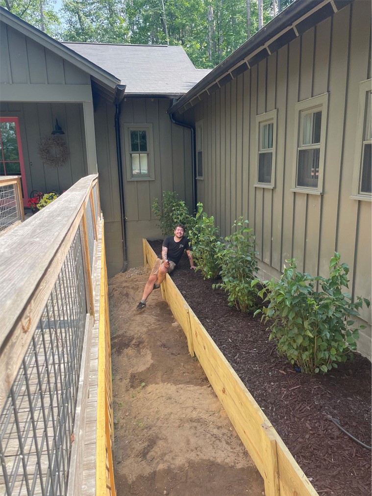 Myles Markey sitting on top of the retaining wall he built.