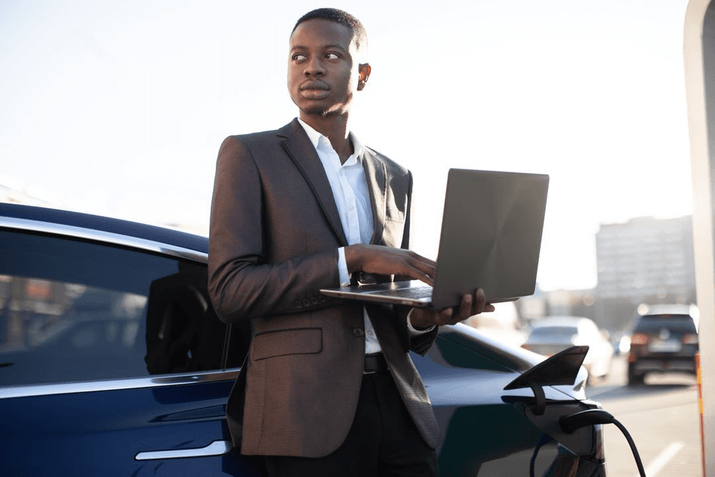 Person Standing next to car with a laptop open