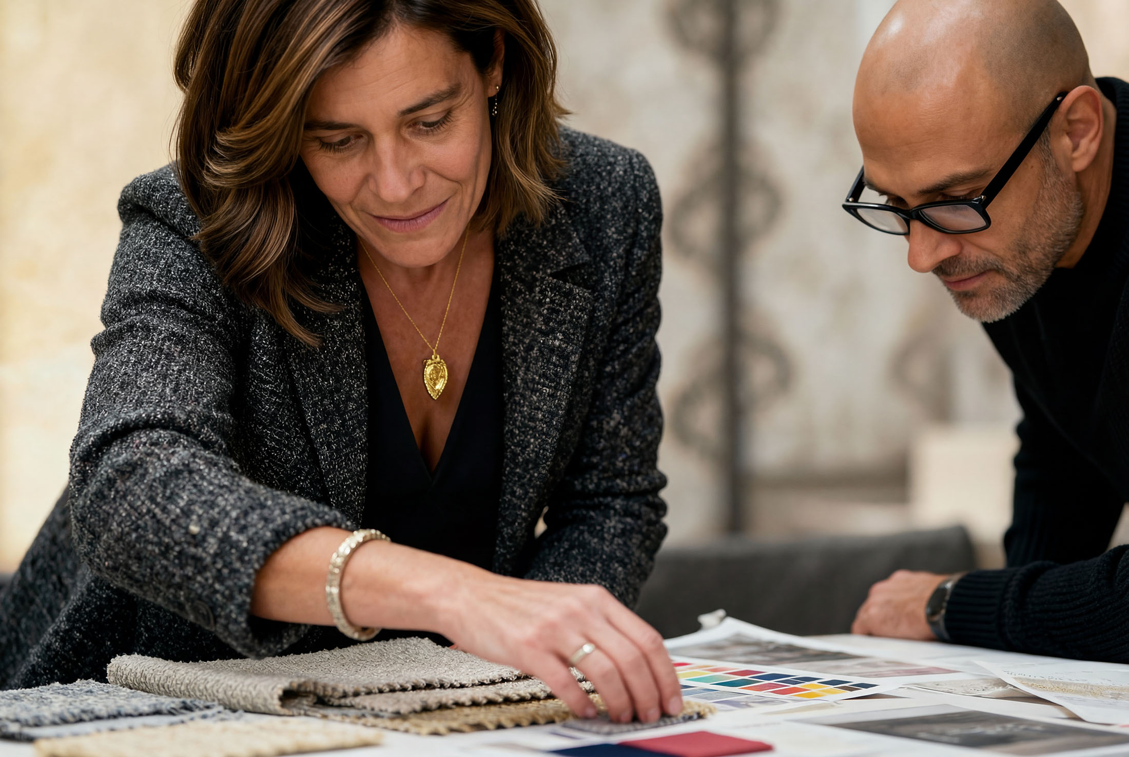 Two people closely examine printed materials on a table, engaged in discussion and analysis.