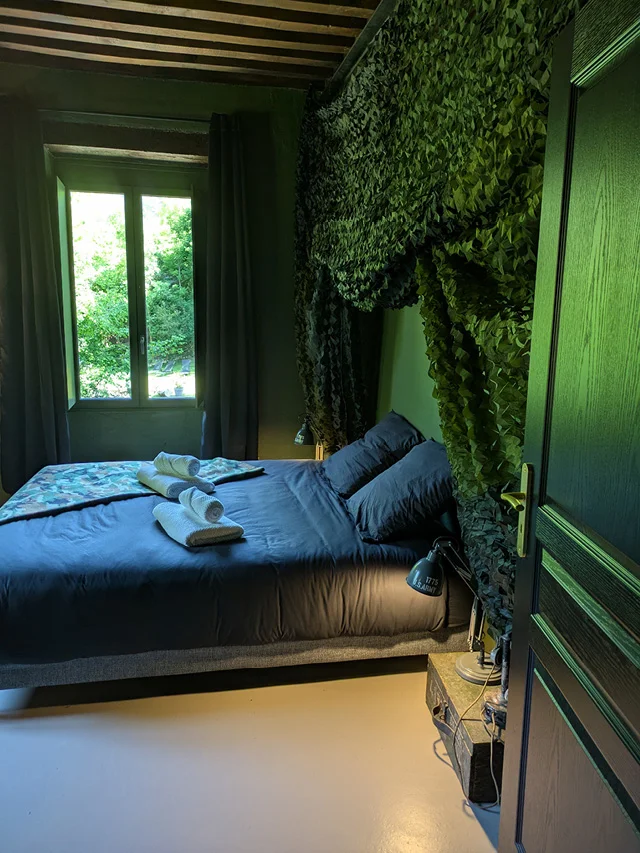 Vue du lit double avec la décoration militaire dans la chambre La Chute de la Tuilerie