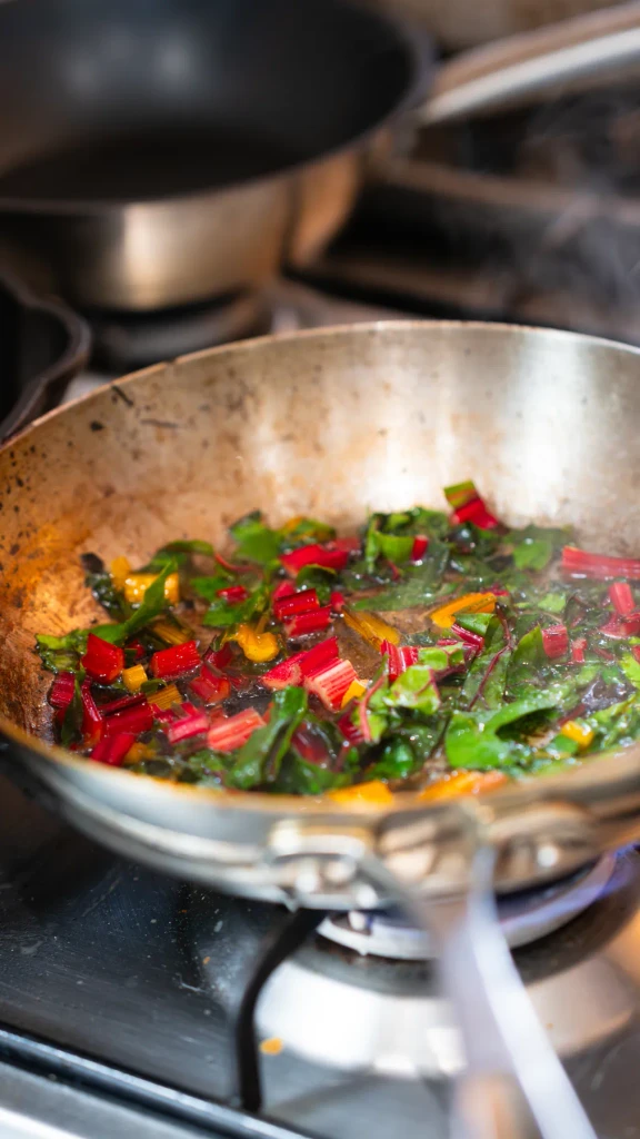 Rainbow chard tossed in a pan over the flame