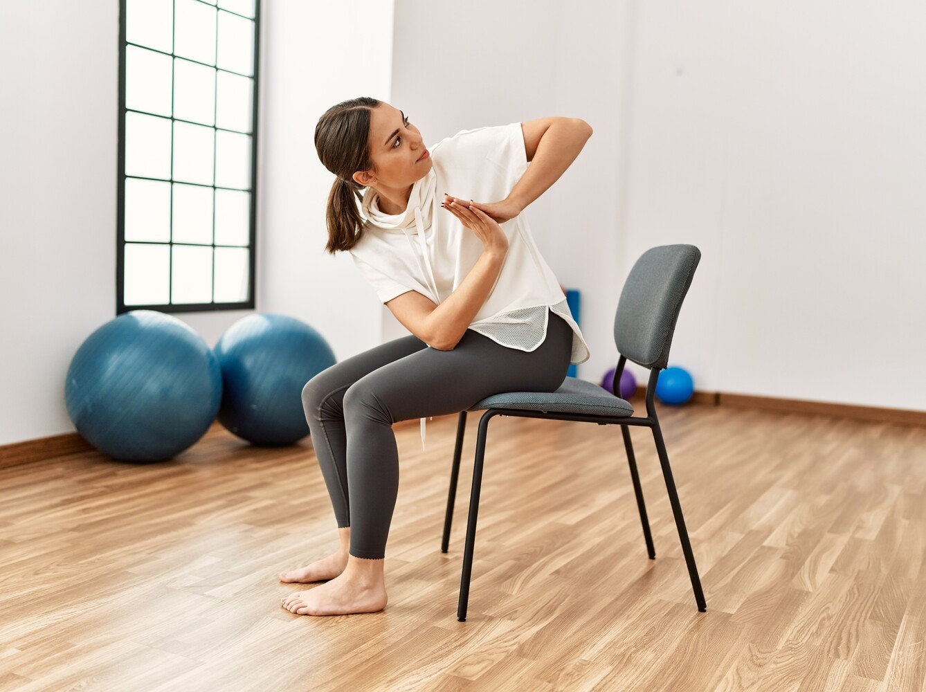 young woman doing chair exercises for weight loss in a studio at the gym