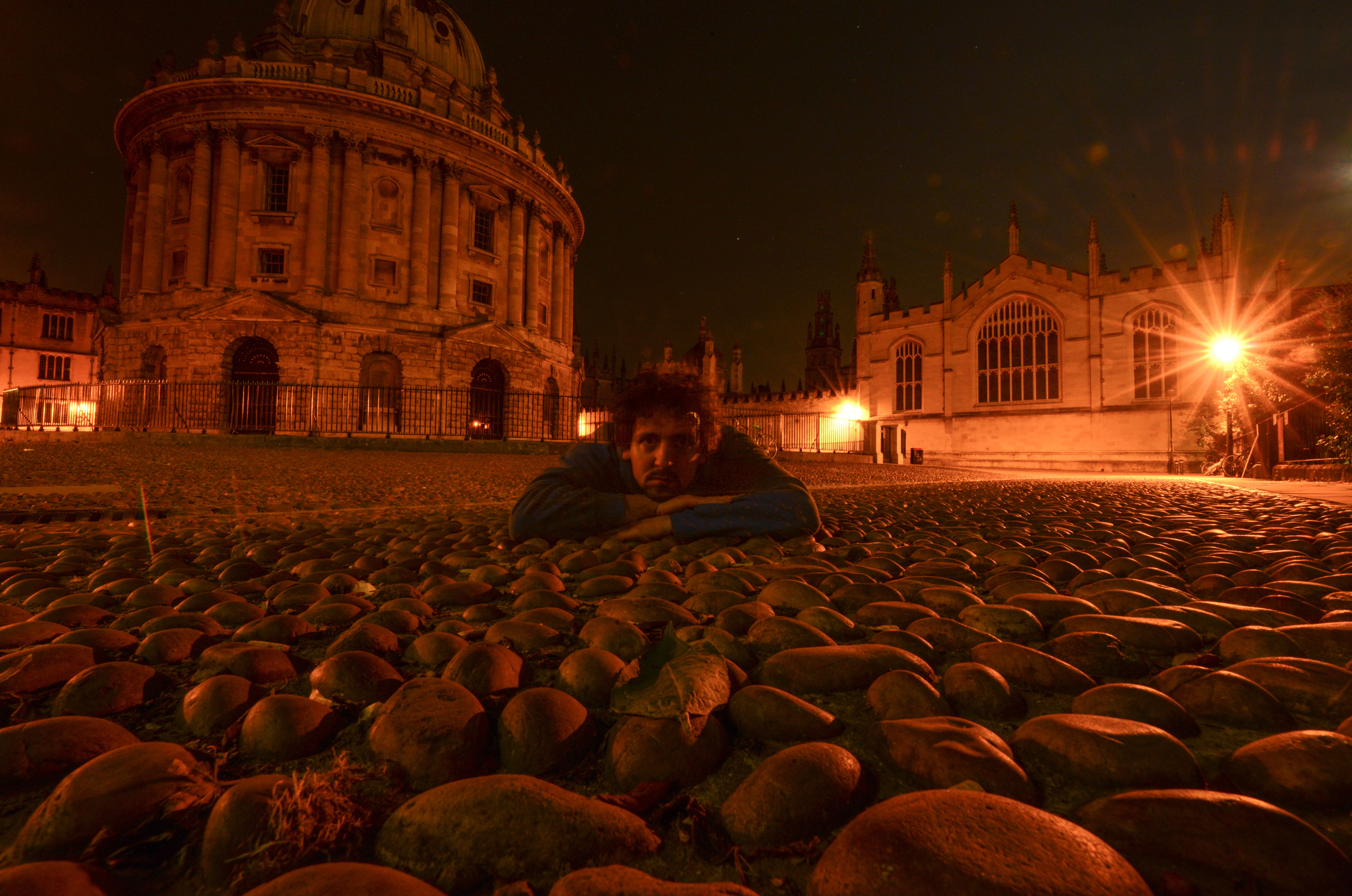 Maurice Voyame reclining in front of Oxford architecture at night