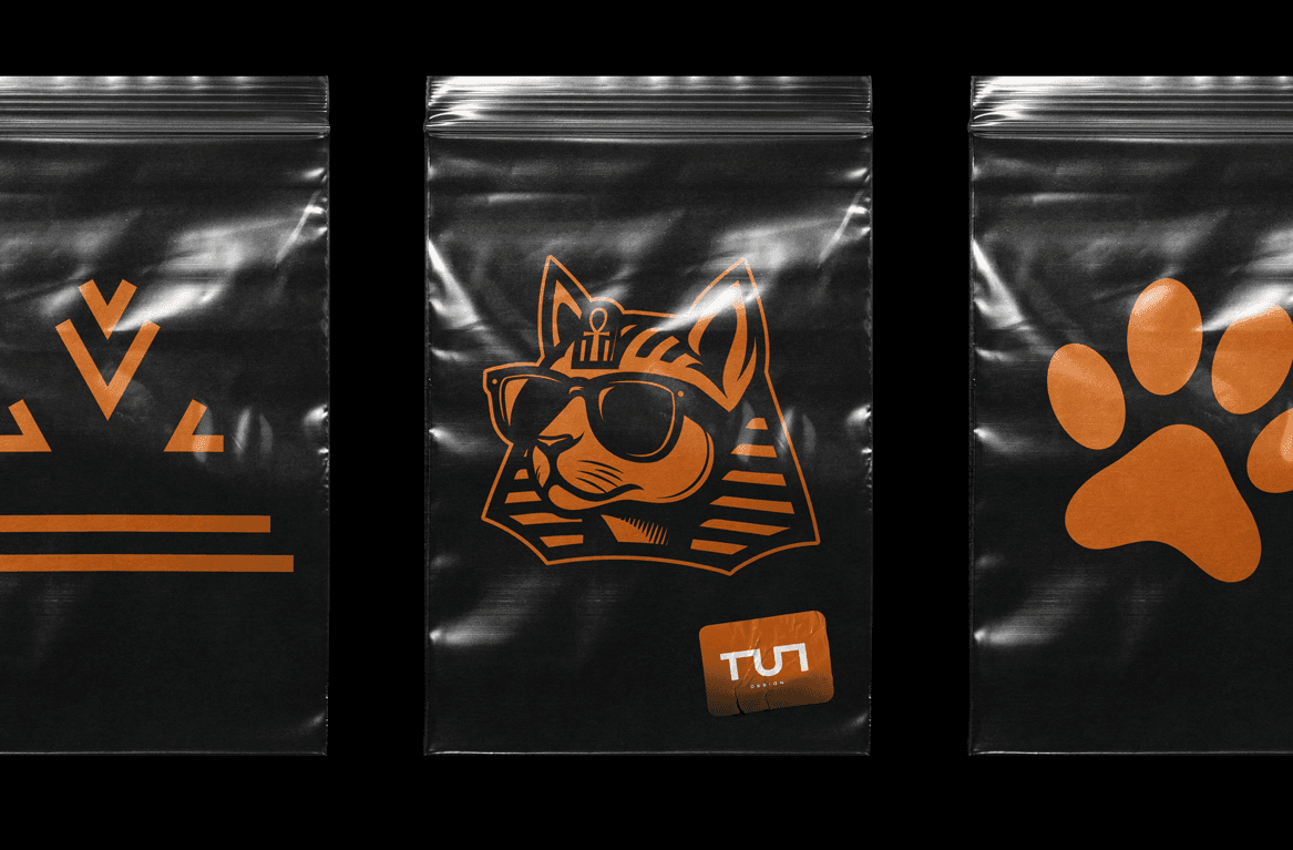 TUT Designs packaging with pharaonic-inspired cat logo, crown, and paw print graphics, blending Egyptian heritage with modern fashion identity.