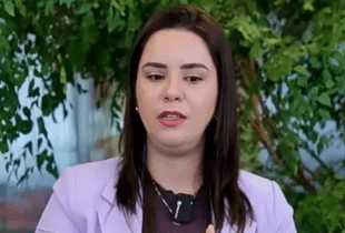 Três pessoas conversam ao ar livre, cercadas por plantas verdes e uma atmosfera relaxante.