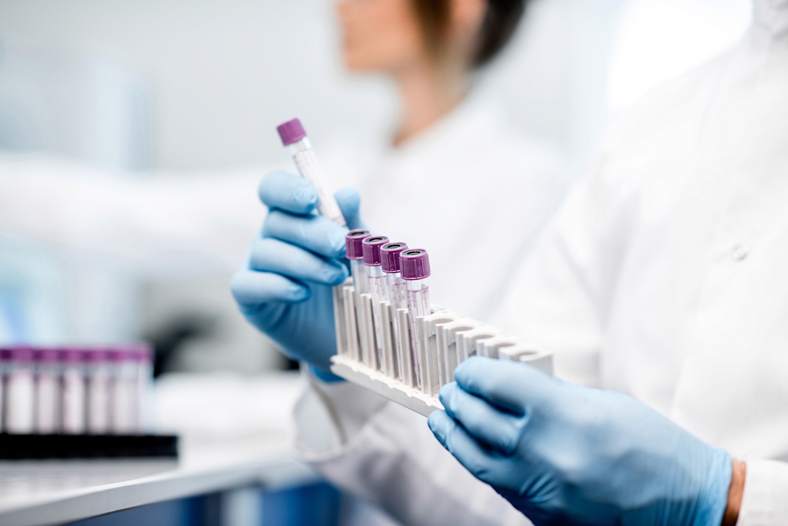 a set of lab tubes held by a scientist 