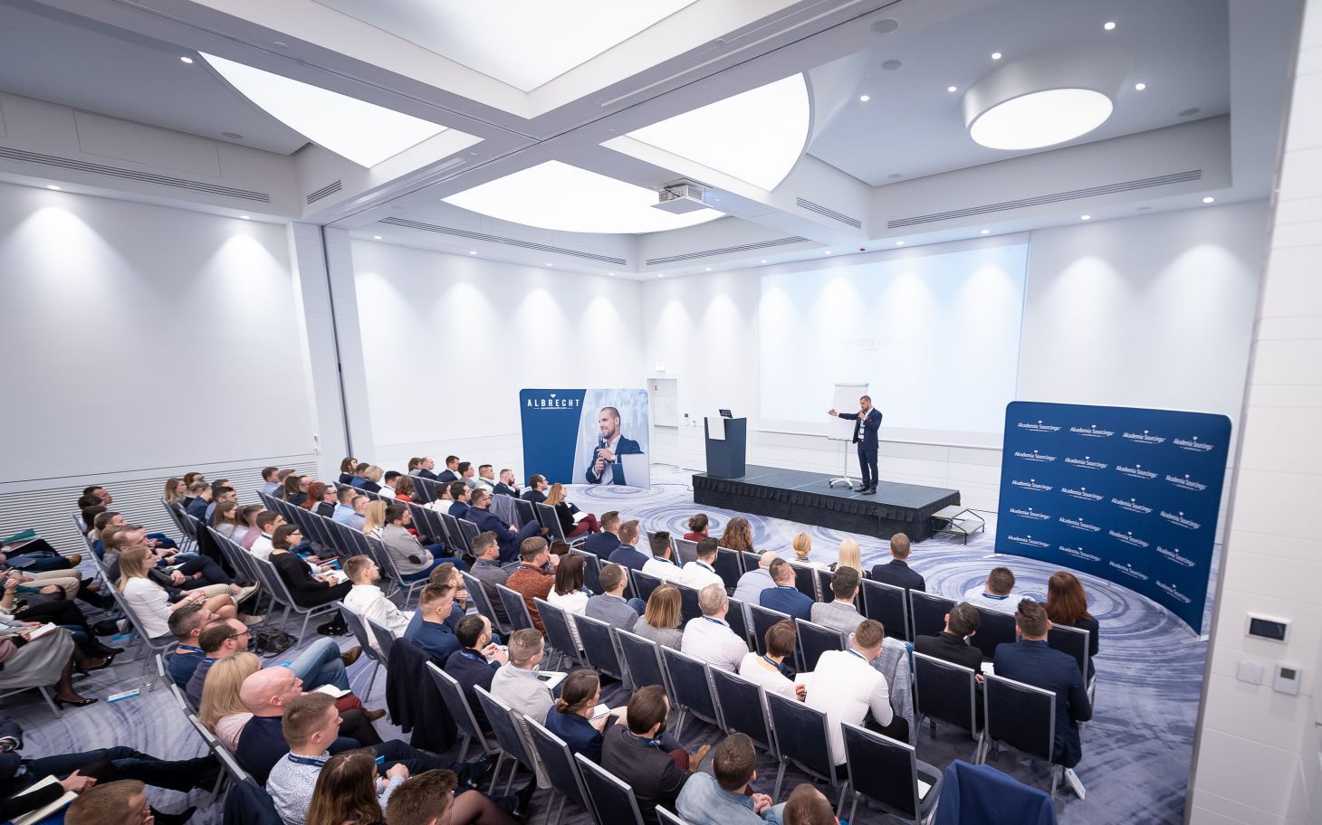 Paweł Albrecht prowadzi wykład o inwestowaniu w nieruchomości na dużej sali konferencyjnej