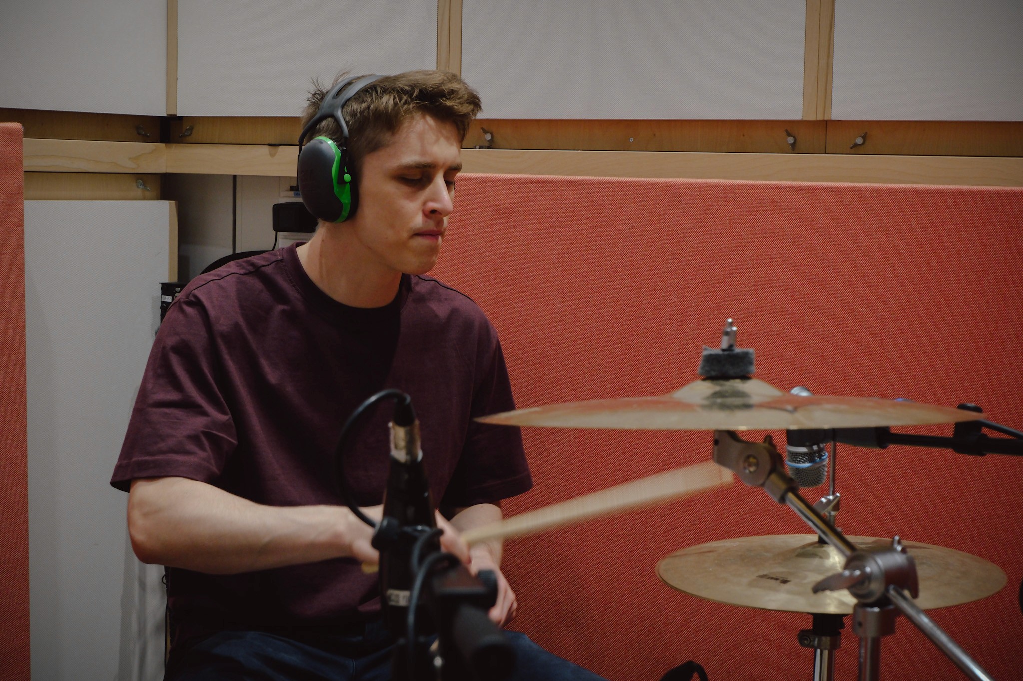 A man playing drums in a recording studio