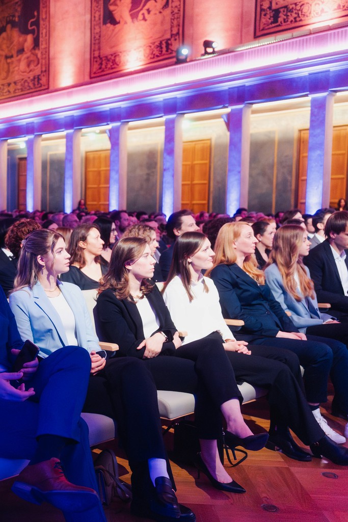 Audience seated in a festively decorated hall at an event