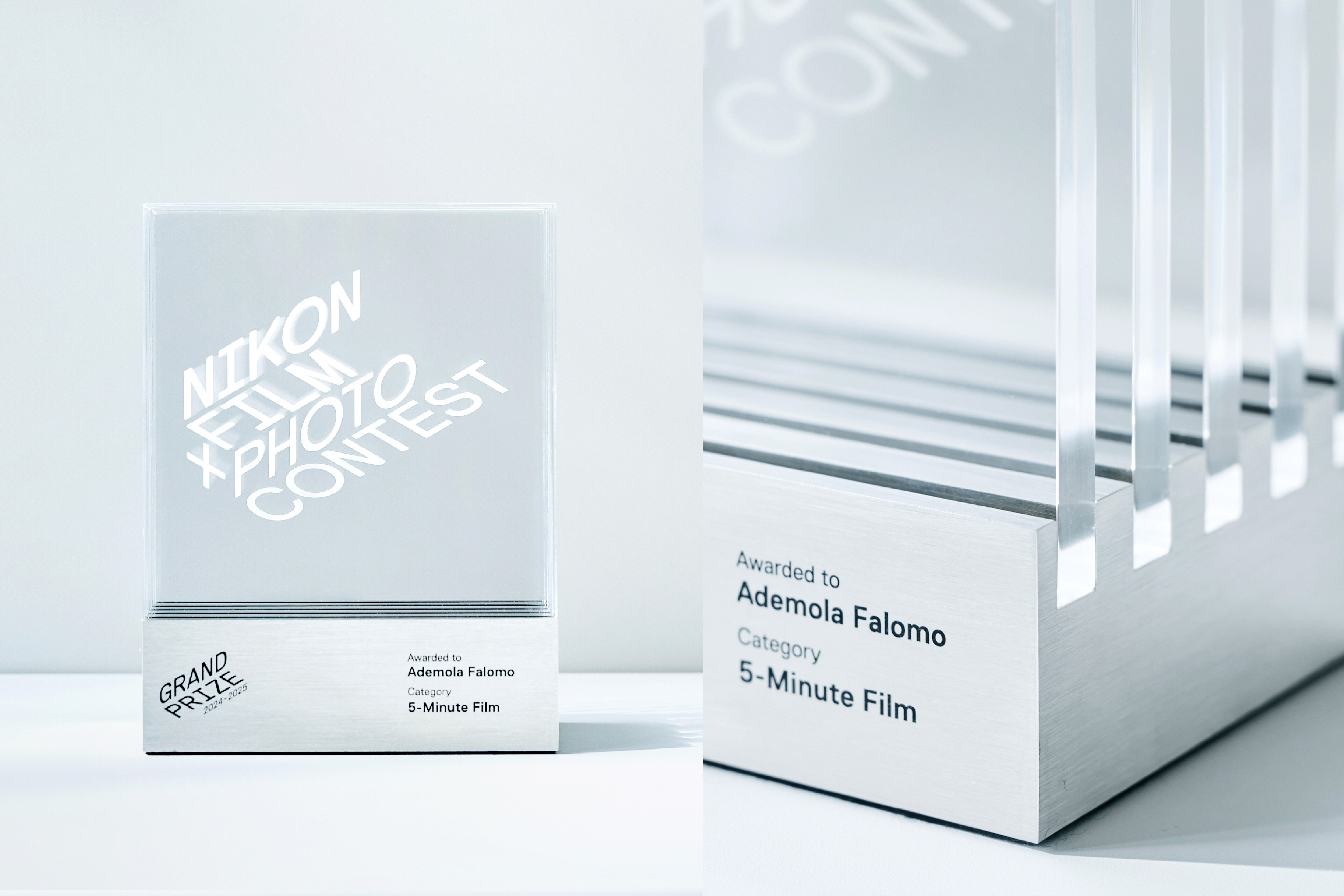 A sleek, minimalist trophy design displayed with white tones and clean lines, featuring a subtle logo.