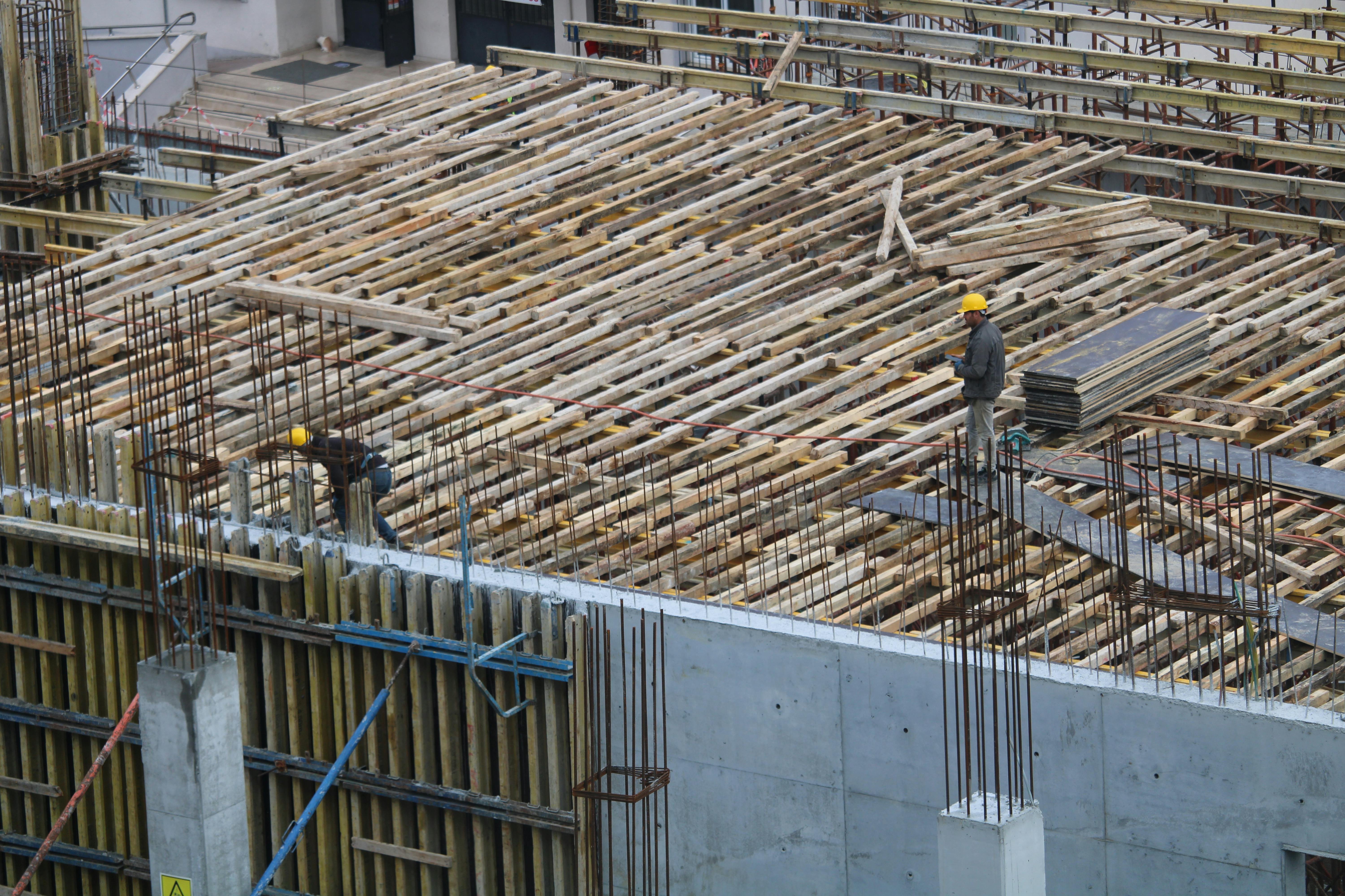 Workers installing rebar for concrete foundation at a construction site