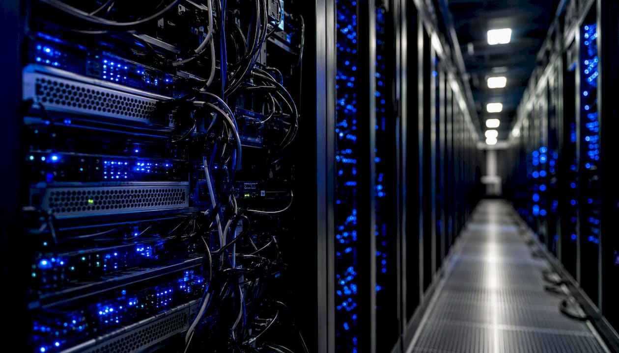Dark server room aisle with cables and lights
