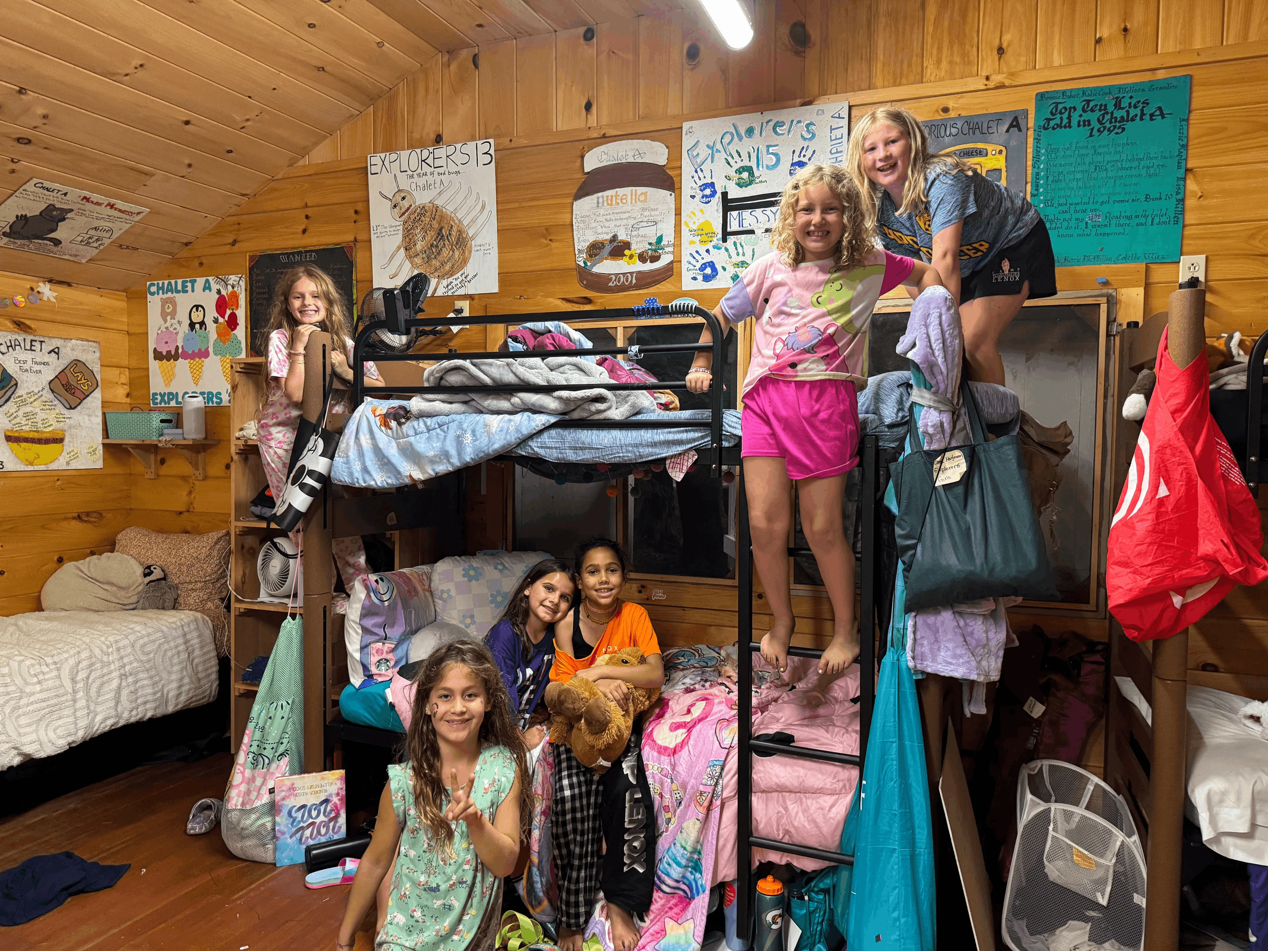 Campers in pajamas posing by their bunk beds at Camp Lenox