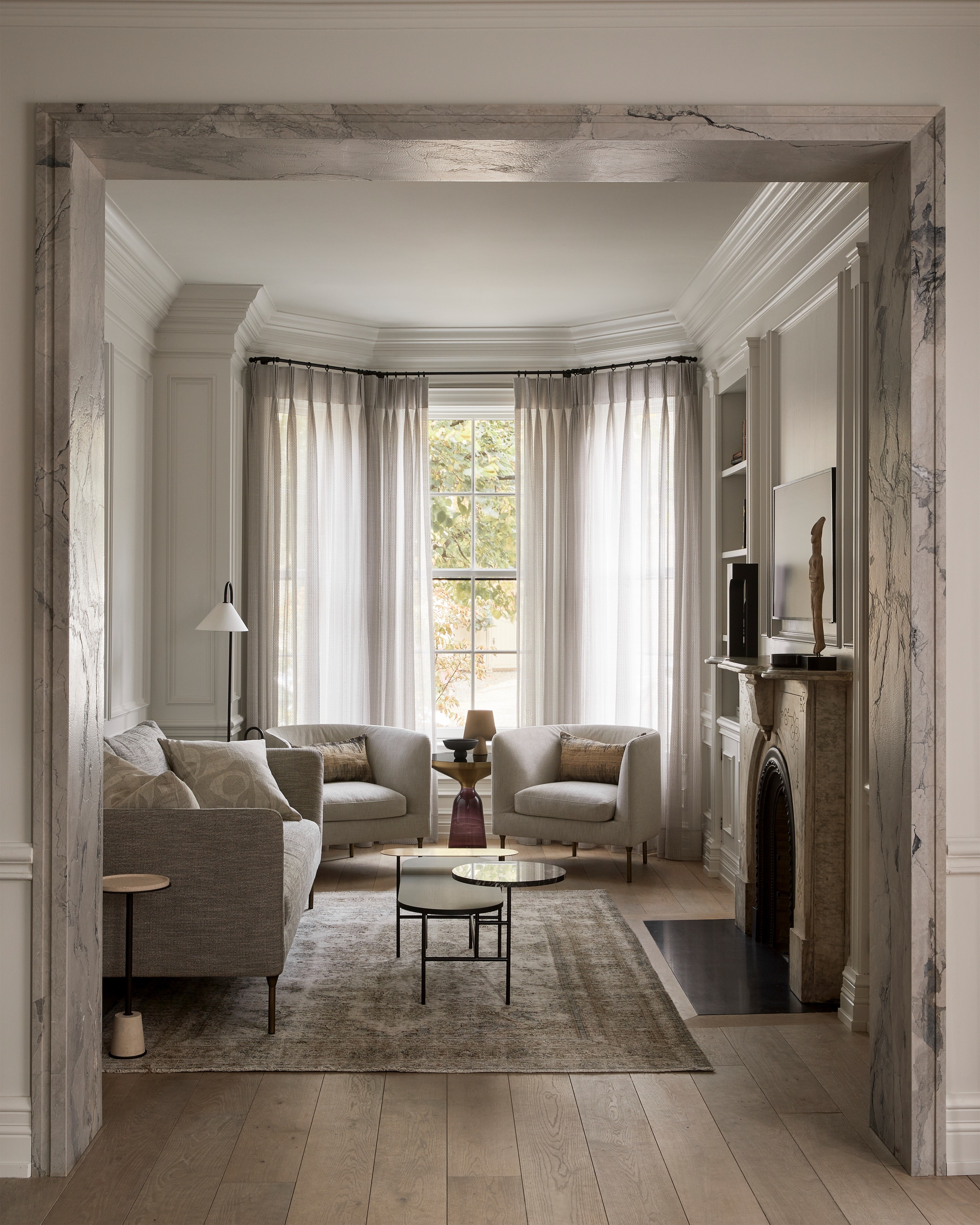 A living room seen through a marble-framed opening in an Annex home