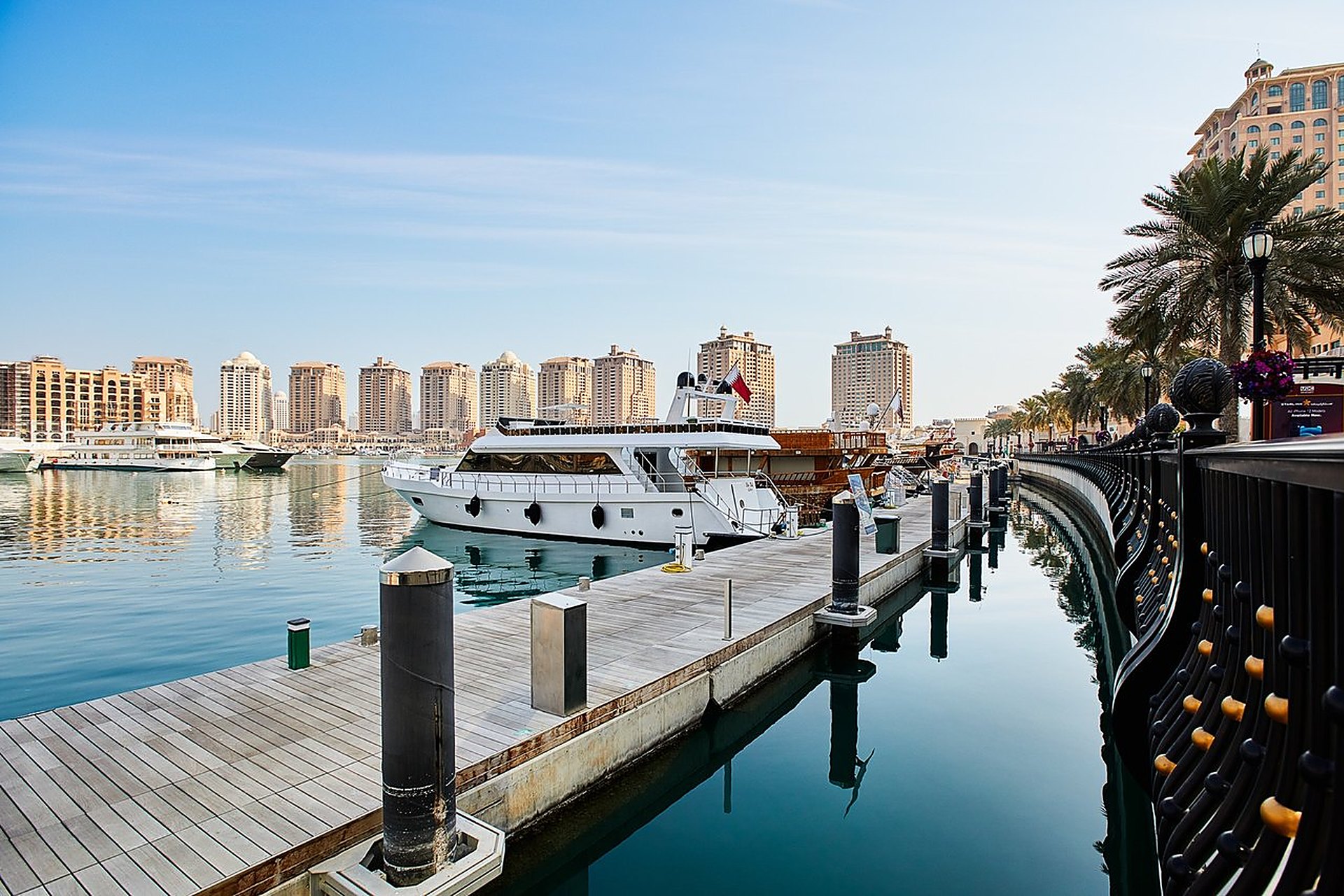 Un yacht amarré au quai de la marina de The Pearl, à Doha, sous un ciel bleu