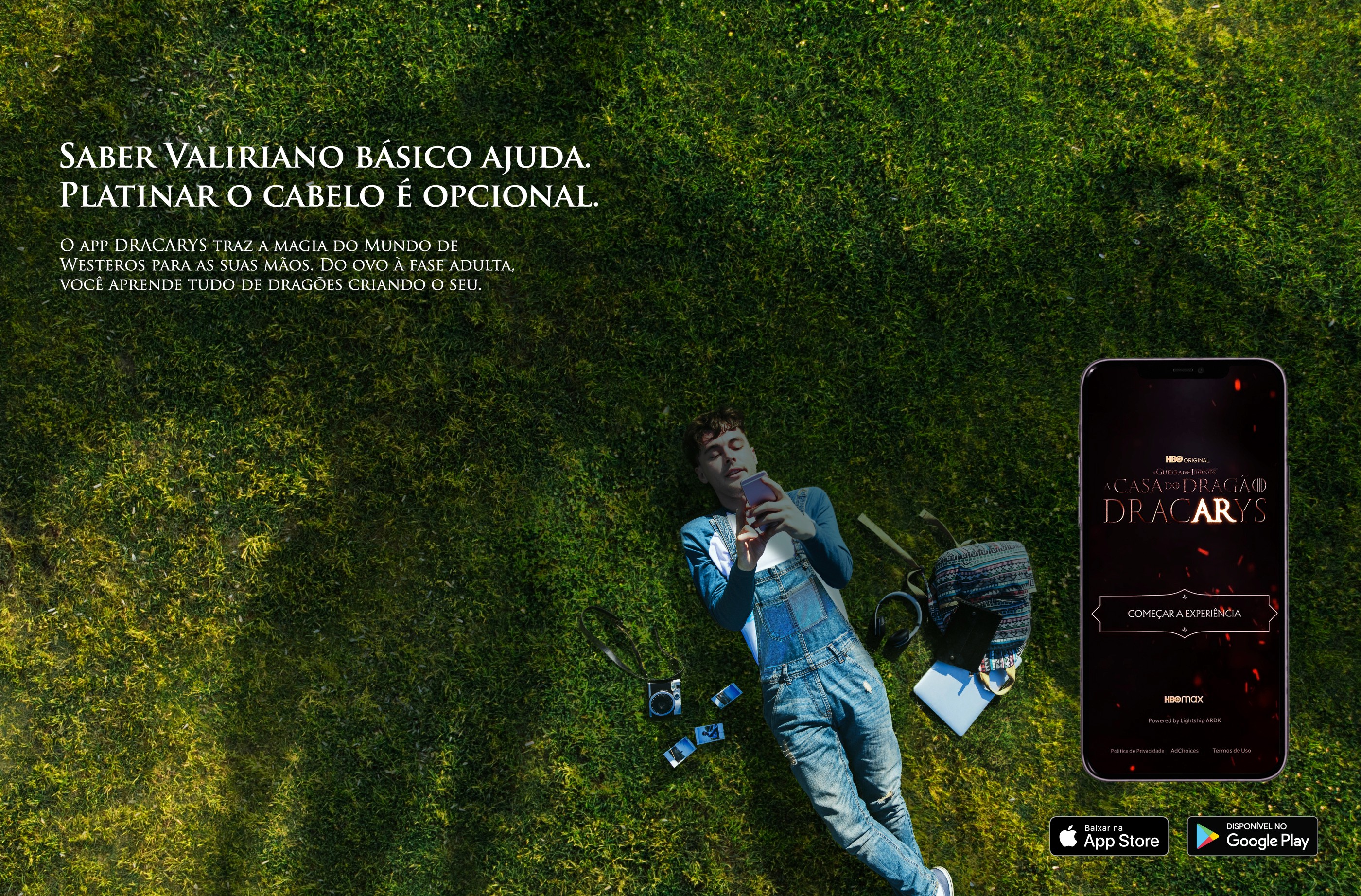 Young man lying on grass using his phone while a dragon’s shadow passes overhead, promoting the DracARys app.