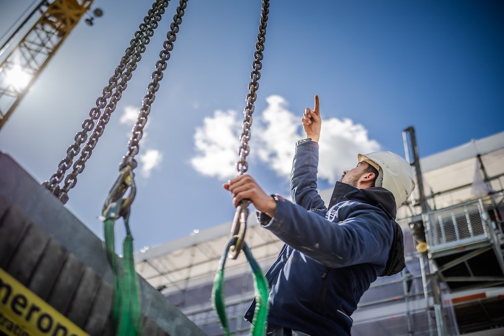 Personeel van BKV staat onderaan de hijskraan.