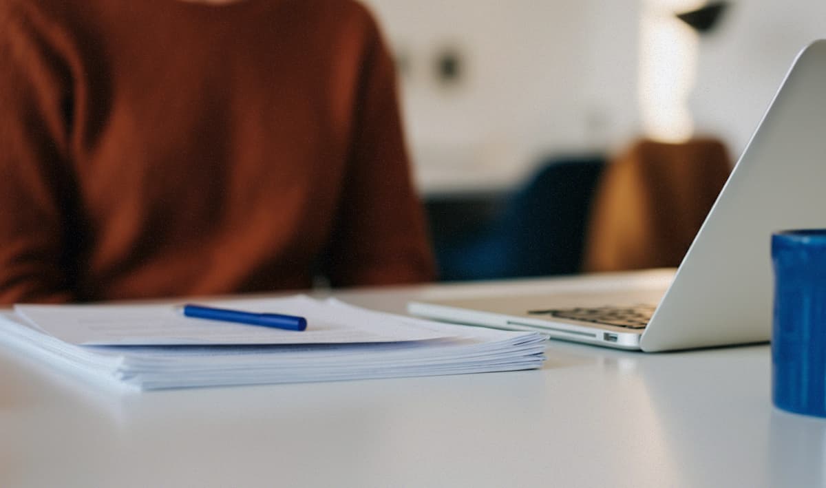 Business meeting at an office table with quality of hire written on a whiteboard in the background