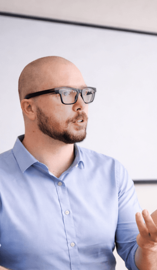Young woman in a white shirt with a colorful gradient print, against a plain background.