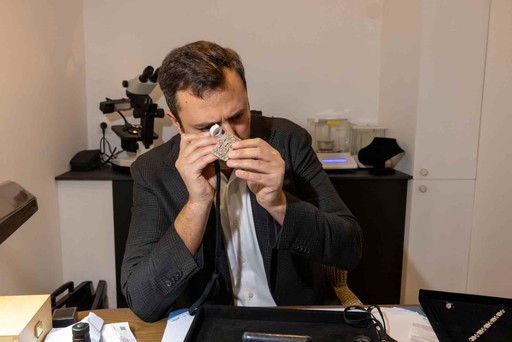 Homme en chemise blanche observant un diamant avec un microscope